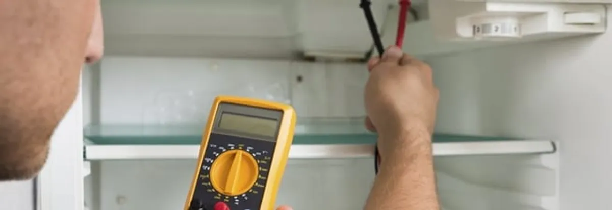 Refrigerator repair technician testing electrical components with a multimeter in Fort Worth, TX