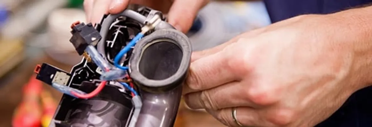 Vacuum repair technician reconnecting wiring and components in Fort Worth, TX