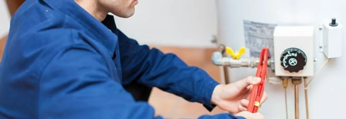Water heater repair technician adjusting the temperature control and gas valve in Fort Worth, TX